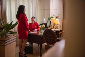una mujer parada frente a un escritorio con una mujer en Kempinski Nile Hotel, Cairo en El Cairo
