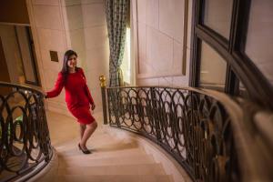 Uma mulher de vestido vermelho a descer uma escada. em Kempinski Nile Hotel, Cairo no Cairo