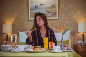 een vrouw die aan een tafel zit eten bij Kempinski Nile Hotel, Cairo in Caïro