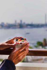 開羅的住宿－開羅凱賓斯基尼羅酒店，手里拿着一碗食物的人