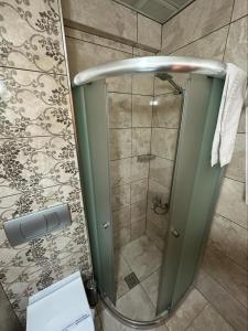 um chuveiro com uma porta de vidro na casa de banho em Sonerbey Otel em Ordu