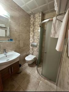 a bathroom with a toilet and a sink and a shower at Sonerbey Otel in Ordu