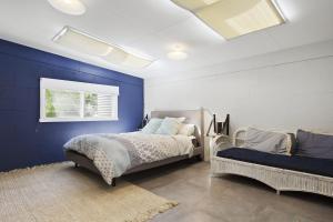 una camera da letto con pareti blu, un letto e una finestra di Budawang a Manyana