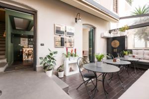 un patio con 2 mesas, sillas y plantas en Hotel Valeri, en Roma