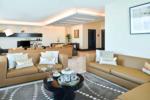 a living room with two couches and a table at Kempinski Residences & Suites, Doha in Doha