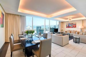 a dining room with a table and a living room at Kempinski Residences & Suites, Doha in Doha