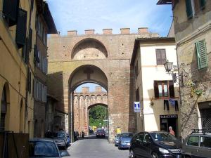 an archway in a building with cars parked on a street at Ampio monolocale nel centro storico di Siena in Siena