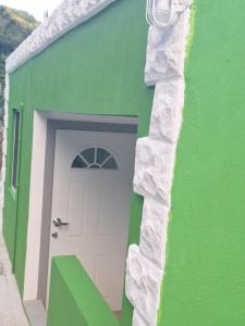 グロス・アイレットにあるAckee Green Rental - 2 bedroom 1 bathroomの緑の建物の脇の扉