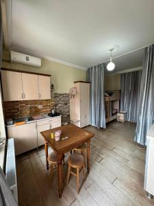 a kitchen with a wooden table and a small table with chairs at TJ+ Hostel in Batumi