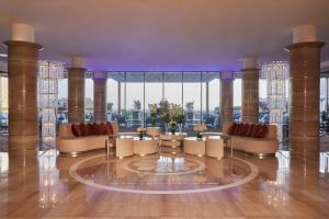 vestíbulo con sillas, mesas y ventanas grandes en Kempinski Hotel Adriatic Istria Croatia, en Savudrija