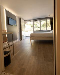 a bedroom with a bed and a tv on the wall at Kyriad Lyon Sud Sainte Foy in Sainte-Foy-lès-Lyon