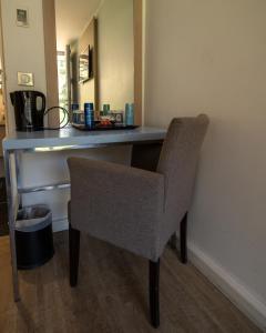 a desk with a chair in a room at Kyriad Lyon Sud Sainte Foy in Sainte-Foy-lès-Lyon