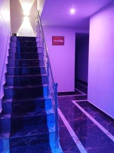 a staircase in a building with purple walls and blue floors at VT beach home leaf in Kumta