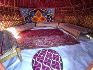 Bett in einer Jurte mit einer Bettdecke und Kissen in der Unterkunft Tunduk son-kol yurt camp in Song-Kul