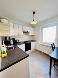 a kitchen with white cabinets and a black counter top at Central City West in Berlin