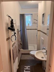 La salle de bains est pourvue d'un lavabo, de toilettes et d'une douche. dans l'établissement Tolles Appartement, zentrumsnahe 2 Schlafzimmer, à Lübeck