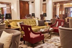 a living room with couches and tables and chairs at Grand Hotel Kempinski Riga in Rīga