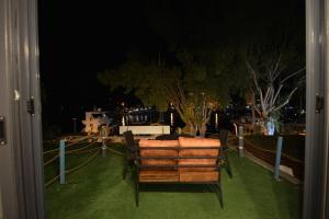 Blick auf einen Garten in der Nacht mit einer Bank in der Unterkunft TRAKHEİA OTEL in Marmaris