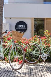 Una bicicleta con una cesta aparcada delante de las flores en 1935 Apartaments by Terraza, en Roses