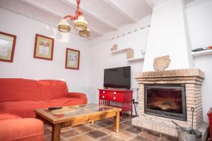 uma sala de estar com um sofá vermelho e uma lareira em Casa Dehesa San Cristóbal, Jaén em Jaén