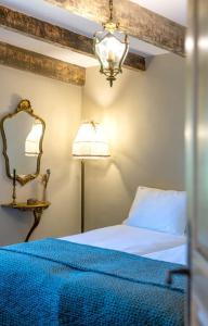 1 dormitorio con cama, espejo y lámpara en Bergerie de Charme Pedi Lione, en Calenzana