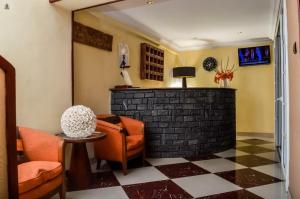 ein Wohnzimmer mit orangefarbenen Stühlen und einem Kamin in der Unterkunft HOTEL LE GRAND PALAIS in Fianarantsoa