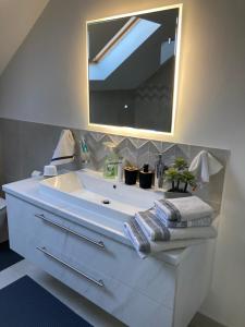 a bathroom with a large white sink with a mirror at Sobe VaLux Valpovo in Valpovo +33 photos