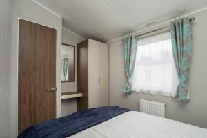Port Seton的住宿－Seton Sands-3 Bed Static Caravan，一间卧室设有一张床和一个窗口