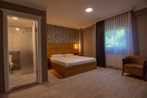 トラブゾンにあるSandal Otelのベッドとバスルーム付きのホテルルームです。