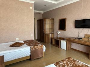 a hotel room with a bed and a flat screen tv at Royal in Aktobe