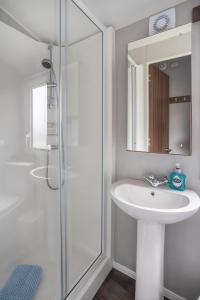 a white bathroom with a sink and a shower at Seton Sands-3 Bed Static Caravan in Port Seton