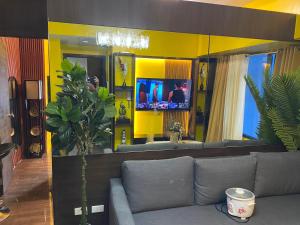 a living room with a couch and a yellow wall at Laugh and Lounge 2 Bedroom Luxury Condo Air residence Makati in Manila