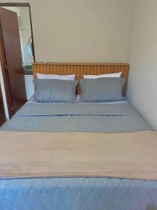uma cama com lençóis e almofadas azuis num quarto em Apartamento Lótus Ar Cond Pertinho FIG e Centro em Garanhuns