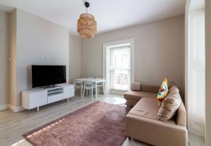 a living room with a couch and a flat screen tv at GuestReady - Relax and Explore in Dundrum in Dublin