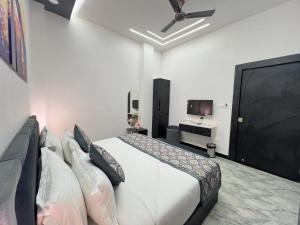 - une chambre avec un lit et une télévision à écran plat dans l'établissement Hotel Sawariya Royal Palace, à Jhālāwār