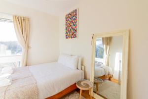 1 dormitorio con 2 camas y espejo en GuestReady - Tranquil retreat in Chapelizod, en Dublín