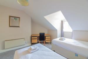 um quarto com 2 camas e uma secretária com uma cadeira em GuestReady - Castle Proximity and Modern Charm em Dublin