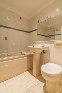 łazienka z toaletą, umywalką i wanną w obiekcie GuestReady - Castle Proximity and Modern Charm w Dublinie