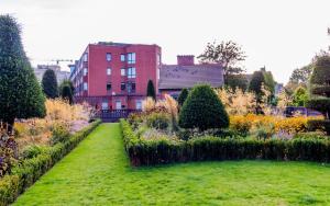 a garden in front of a red building at GuestReady - Lively Apt near Dublin Castle in Dublin