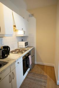 uma cozinha com armários brancos e um forno com placa de fogão em GuestReady - Beautiful Apartment in Dublin 4 em Dublin