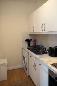 a kitchen with a sink and a washing machine at GuestReady - Beautiful Apartment in Dublin 4 in Dublin