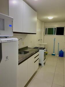 uma cozinha com armários brancos e um lavatório em Apartamento Lótus Ar Cond Pertinho FIG e Centro em Garanhuns