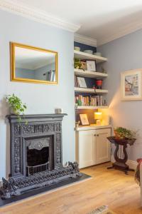 a living room with a fireplace and a mirror at GuestReady - Charming House in East Wall in Dublin