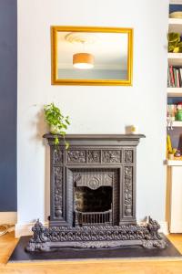 a fireplace in a living room with a mirror at GuestReady - Charming House in East Wall in Dublin