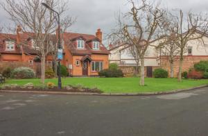 a house with trees in front of a street at GuestReady - Coastal Charm near Sandymount Beach in Dublin