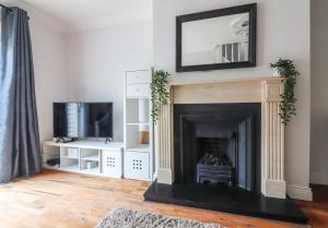 a living room with a fireplace with a mirror above it at GuestReady - Coastal Charm near Sandymount Beach in Dublin