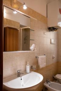 een badkamer met een wastafel, een spiegel en een toilet bij Hola Cathedral House in Palermo