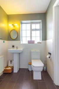 a bathroom with a toilet and a sink and a window at GuestReady - Charming House in East Wall in Dublin