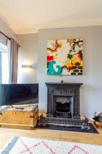 a living room with a fireplace and a painting on the wall at GuestReady - Charming House in East Wall in Dublin