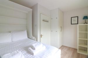 a bedroom with a white bed with two towels on it at GuestReady - Coastal Charm near Sandymount Beach in Dublin